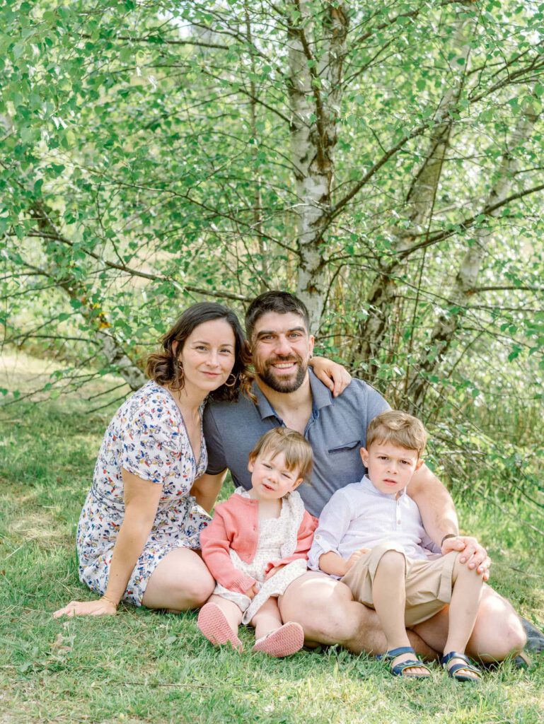 Photo de famille assise dans l'herbe dans un parc
