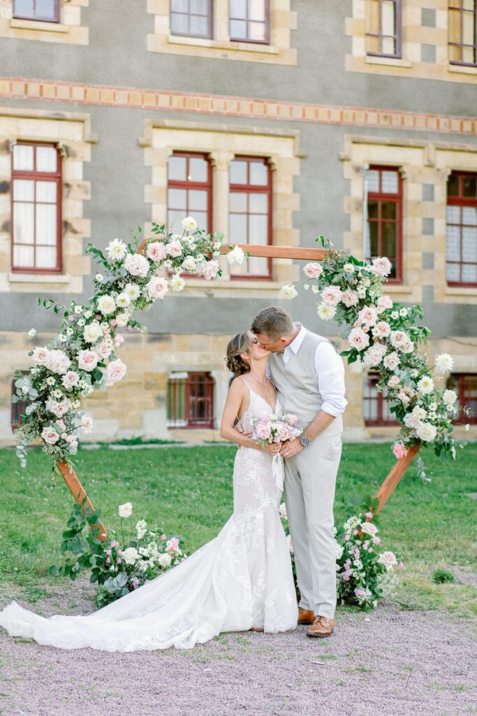 bride and groom in front of the arch