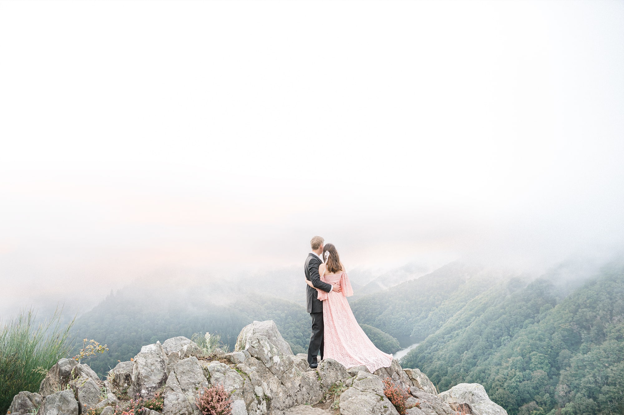 Couple on a cliff with a view on the mountains