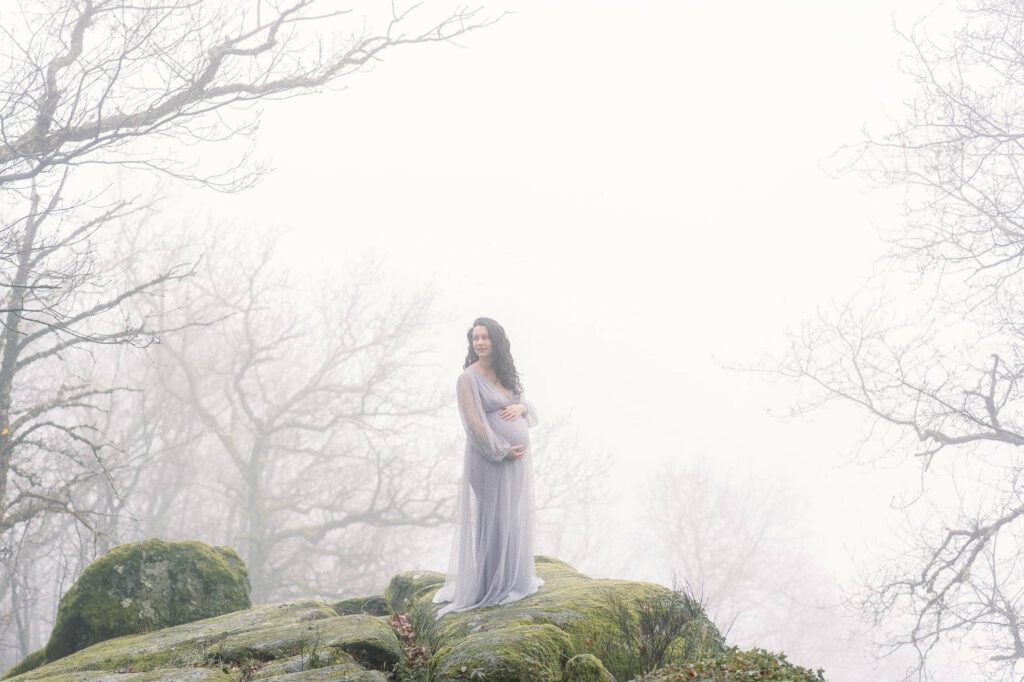 femme enceinte sur un rocher dans la brume