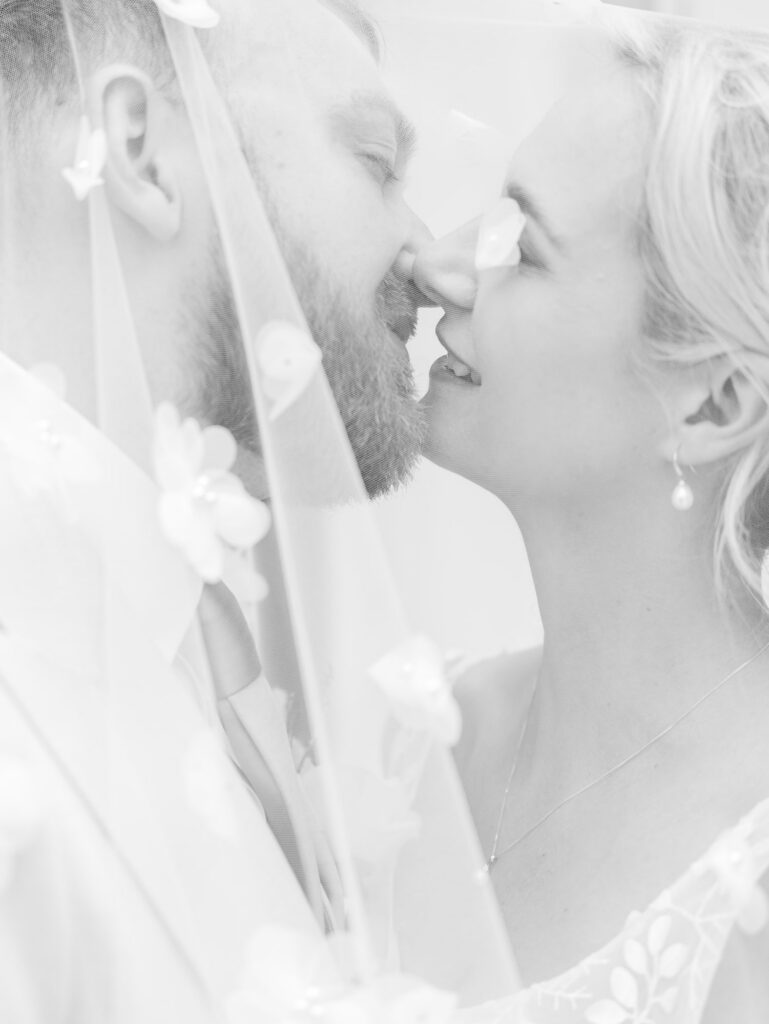 bride and groom kissing behind the veil