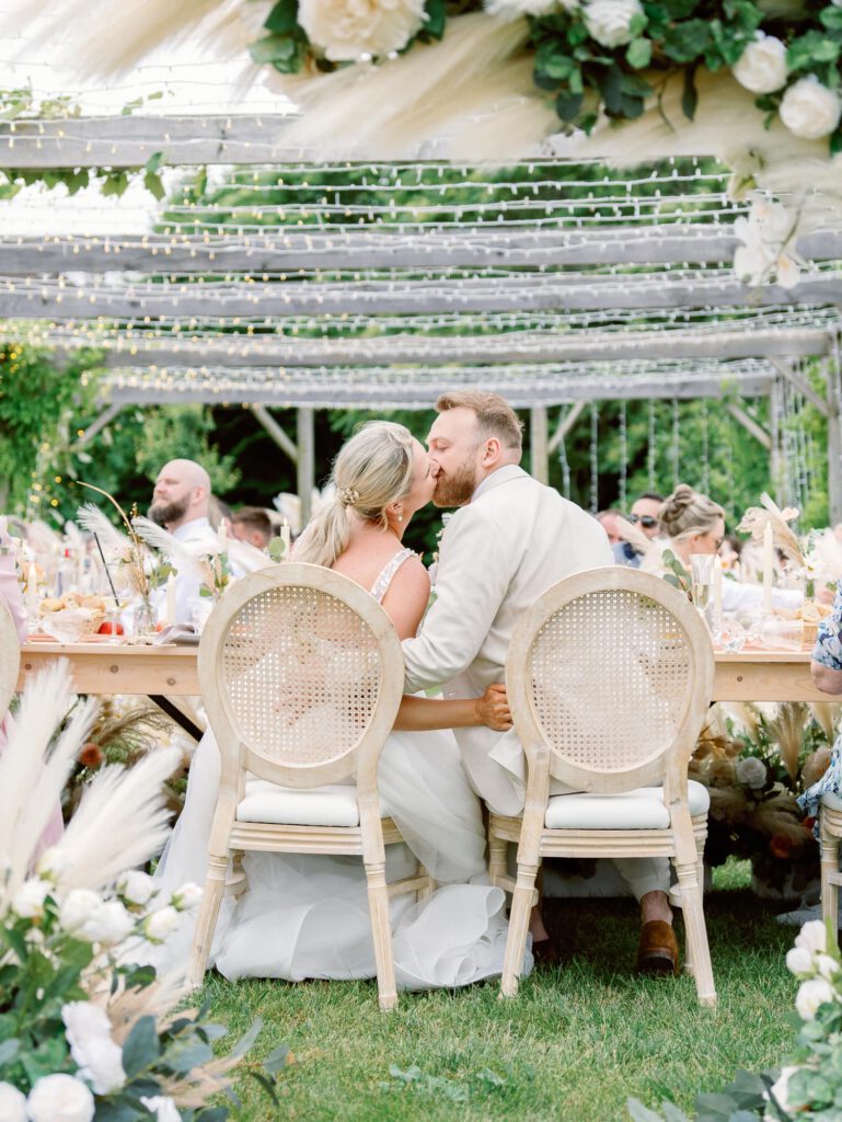 bride and groom kissing at their table