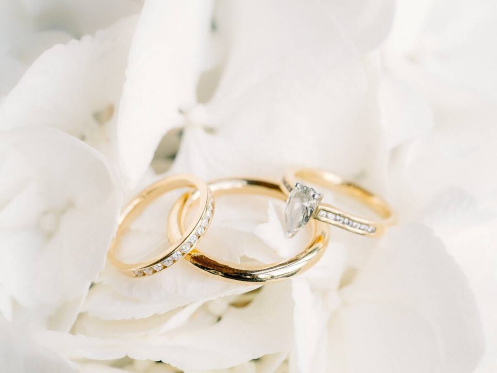 golden wedding rings on white flowers