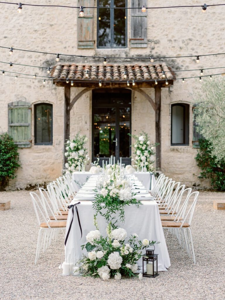 wedding table at clos des charmes with a white tablecloth, white flowers, foliage