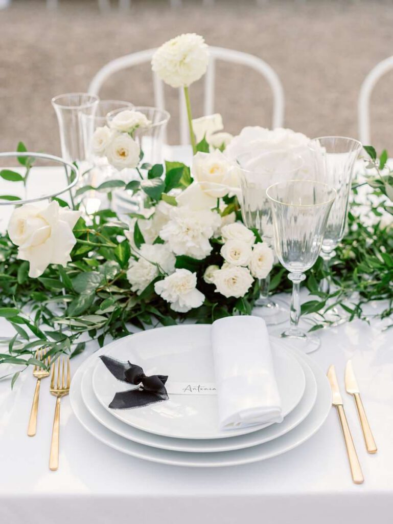 wedding table at clos des charmes with a white tablecloth, white flowers, foliage