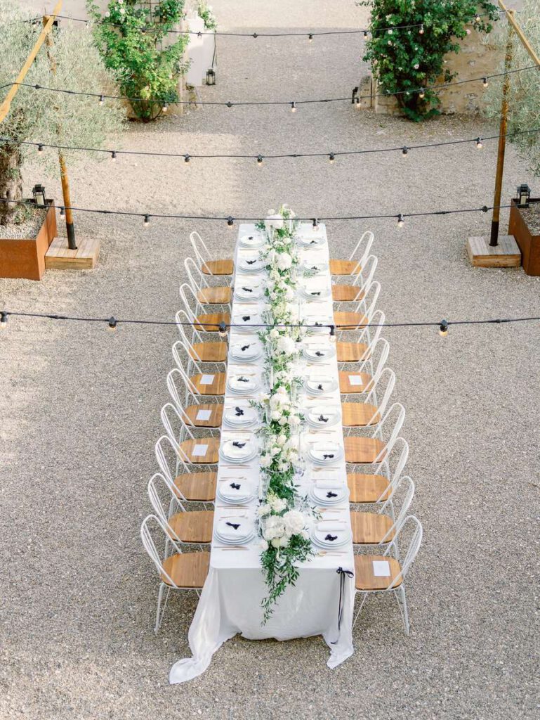 wedding table at clos des charmes with a white tablecloth, white flowers, foliage