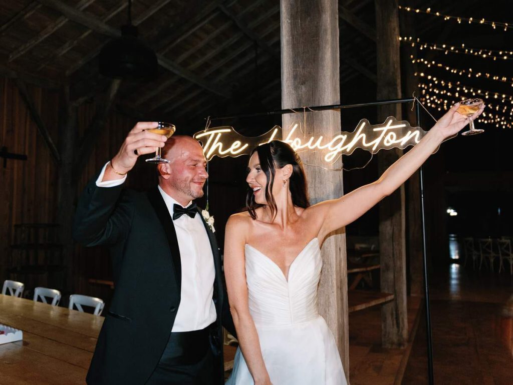 bride and groom in front of the neon sign