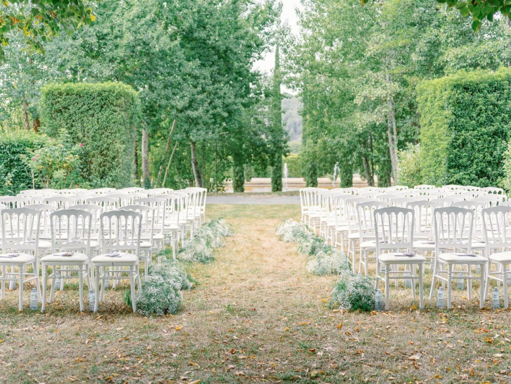 Wedding ceremony with white flowers and chairs at Domaine d'Essendieras
