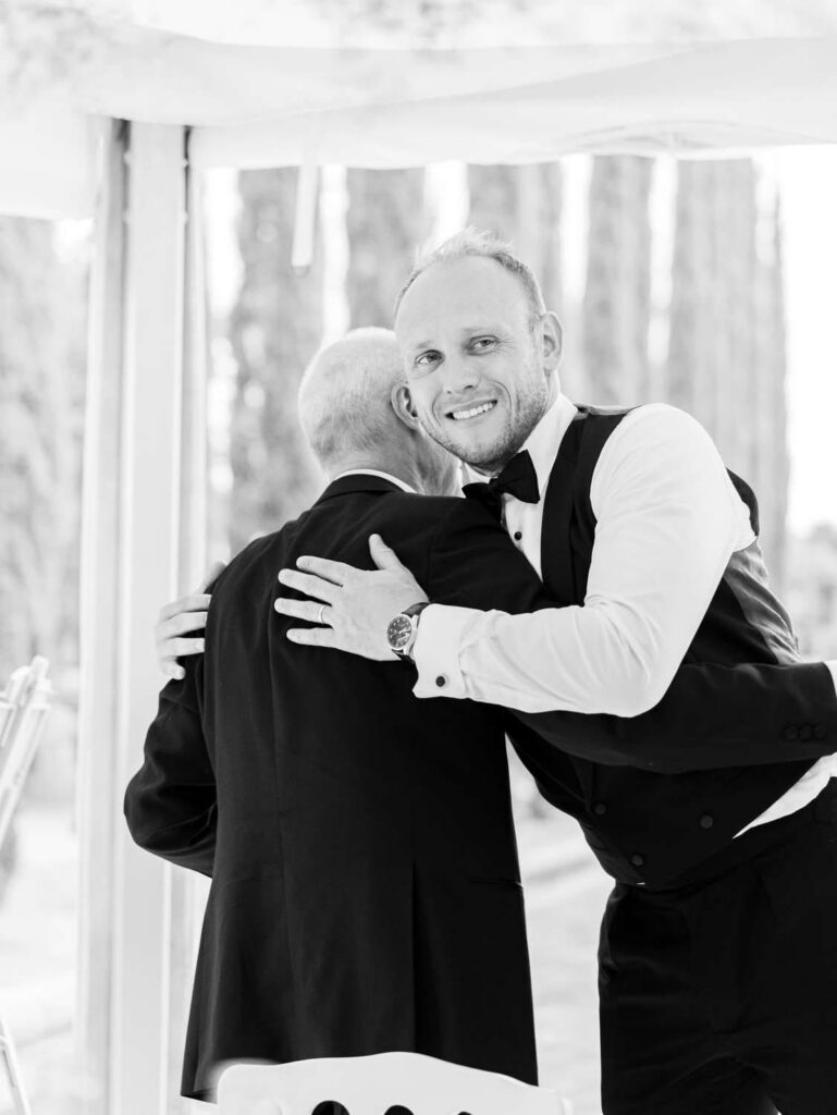 groom hugging the father