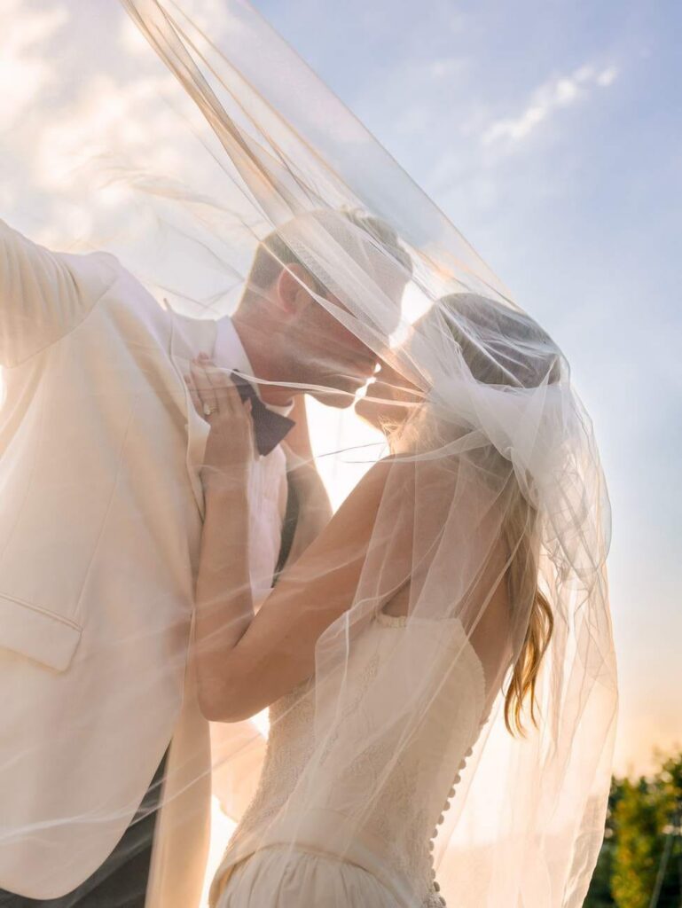bride and groom under a veil